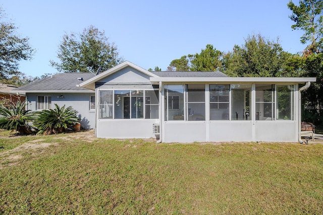 rear view of house featuring a sunroom and a yard