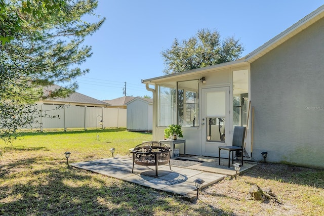 view of yard with a shed, a patio, and a fire pit