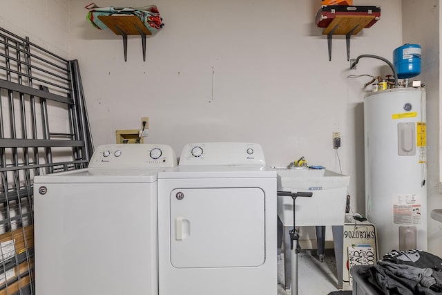 clothes washing area featuring water heater, sink, and washer and dryer