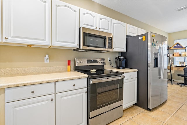 kitchen featuring white cabinets, light tile patterned floors, and stainless steel appliances