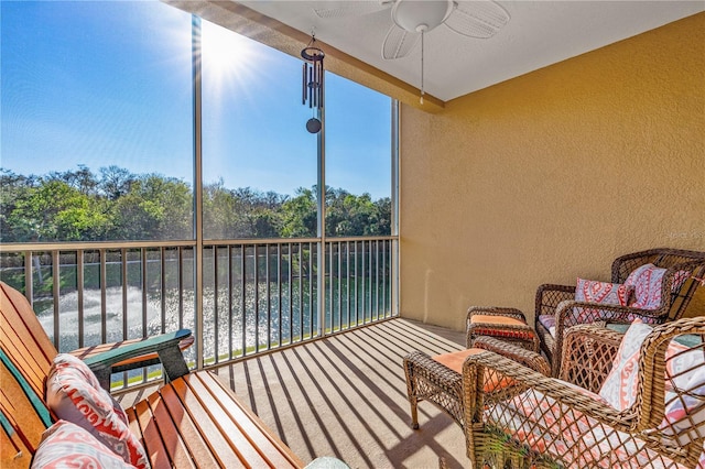 balcony featuring ceiling fan and a water view