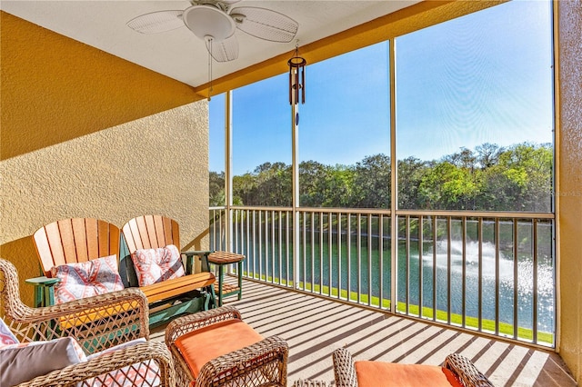 sunroom / solarium featuring a water view and ceiling fan