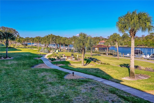 view of property's community featuring a lawn and a water view