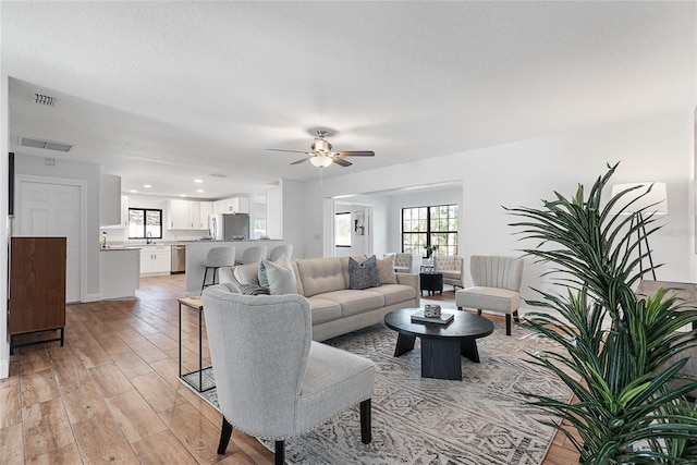 living room with ceiling fan and light wood-type flooring