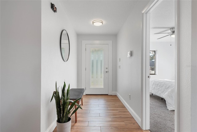 doorway featuring ceiling fan and light wood-type flooring