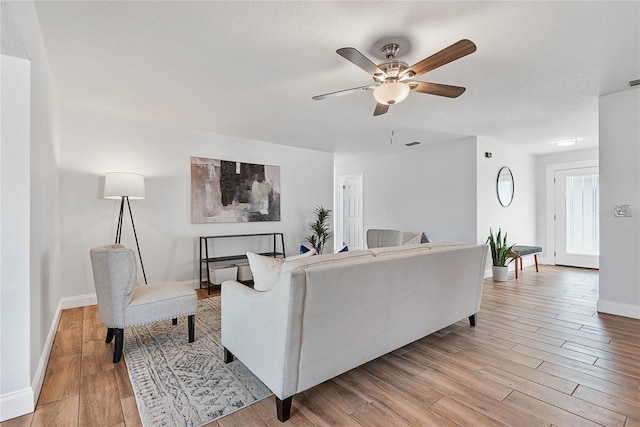 living room with ceiling fan and light hardwood / wood-style floors