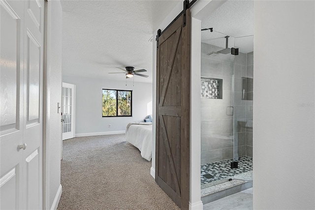 interior space with a textured ceiling, ceiling fan, and a shower with shower door