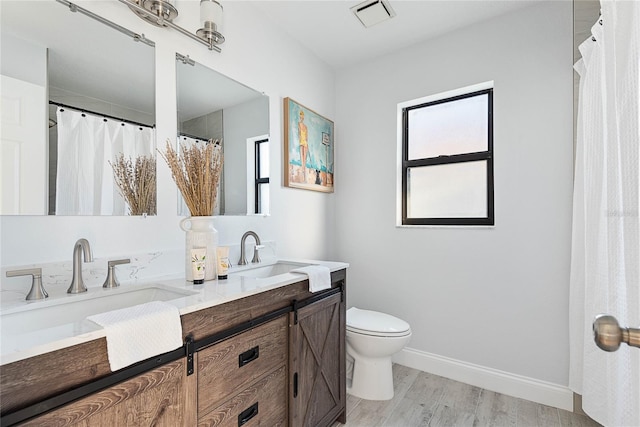 bathroom with hardwood / wood-style flooring, vanity, and toilet