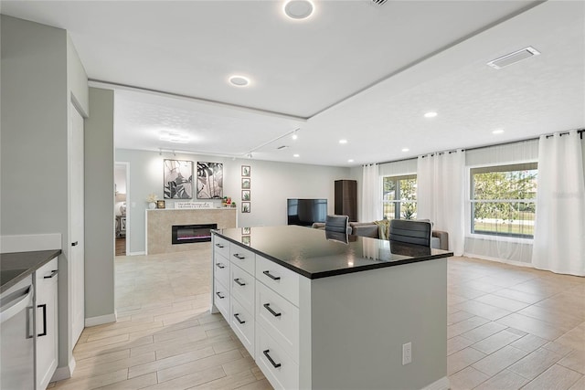 kitchen with a center island, white cabinetry, and stainless steel dishwasher