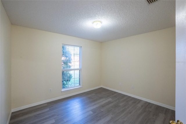 unfurnished room with a textured ceiling and dark wood-type flooring