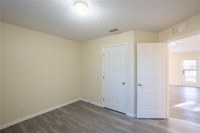 unfurnished bedroom featuring light hardwood / wood-style flooring and a textured ceiling