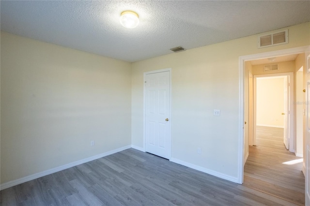 unfurnished room with dark hardwood / wood-style floors and a textured ceiling