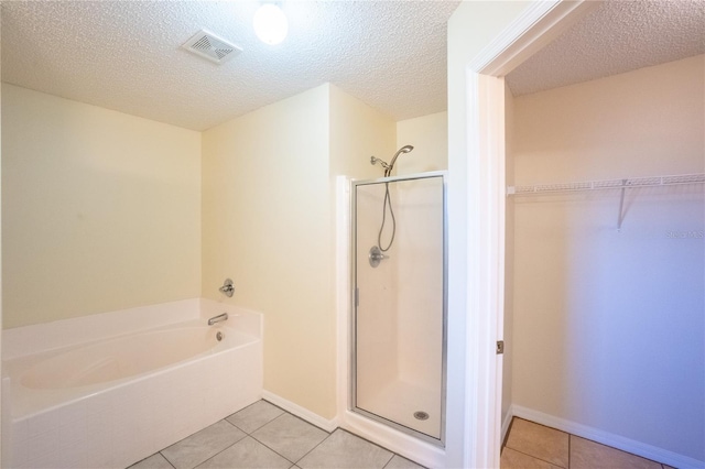 bathroom featuring tile patterned floors, a textured ceiling, and shower with separate bathtub