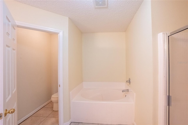 bathroom featuring tile patterned floors, toilet, a textured ceiling, and independent shower and bath