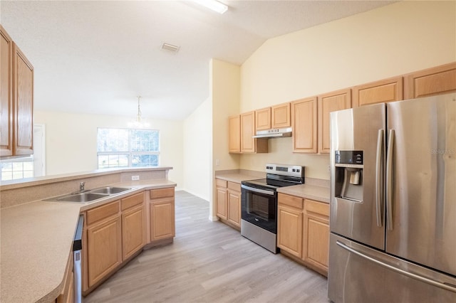 kitchen featuring light brown cabinetry, stainless steel appliances, vaulted ceiling, an inviting chandelier, and hanging light fixtures