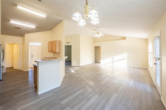 kitchen featuring stainless steel refrigerator, light brown cabinetry, ceiling fan with notable chandelier, and a textured ceiling