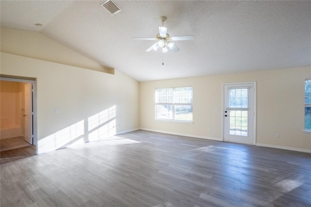 unfurnished room with a textured ceiling, dark hardwood / wood-style floors, ceiling fan, and lofted ceiling