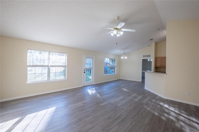 unfurnished living room with ceiling fan with notable chandelier, a textured ceiling, dark hardwood / wood-style flooring, and lofted ceiling