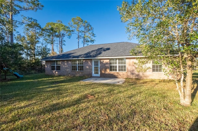 back of house featuring a lawn and a patio