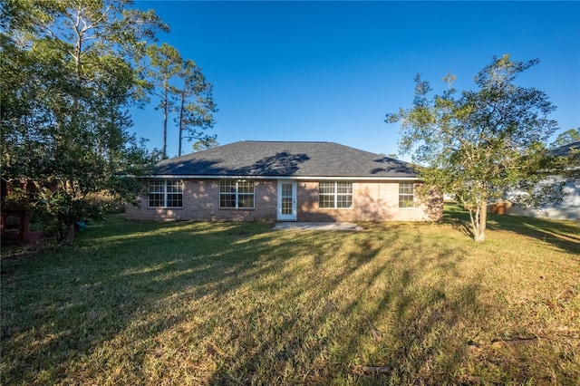 rear view of house featuring a yard