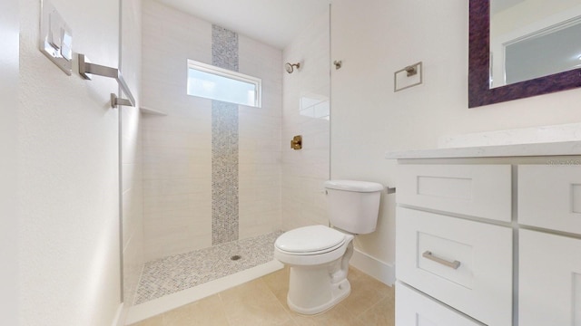 bathroom with tile patterned floors, toilet, and a tile shower