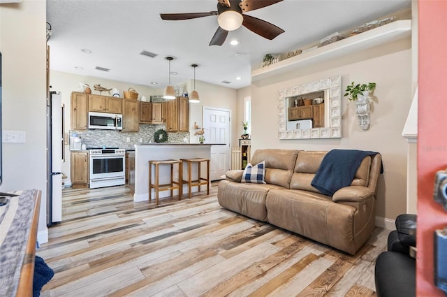 living room featuring ceiling fan and light hardwood / wood-style floors