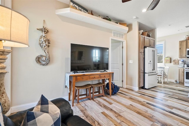 living room with ceiling fan and light wood-type flooring