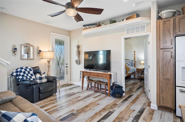 living room with light wood-type flooring and ceiling fan