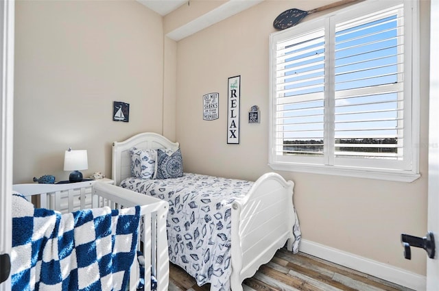 bedroom featuring multiple windows and hardwood / wood-style flooring