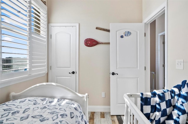 bedroom with multiple windows and light hardwood / wood-style flooring