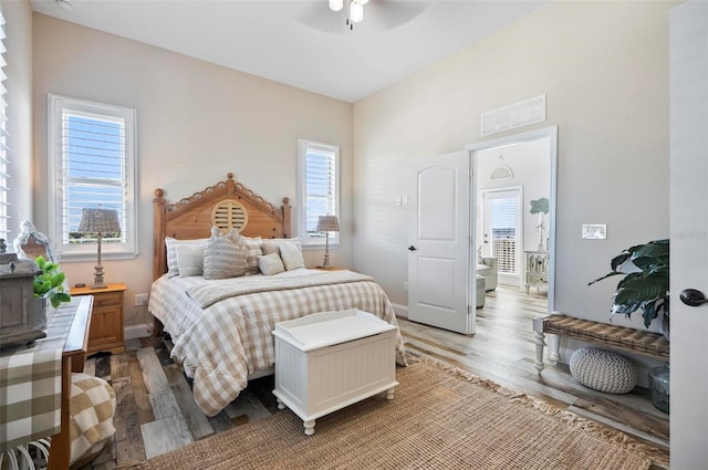 bedroom with multiple windows, hardwood / wood-style flooring, and ceiling fan