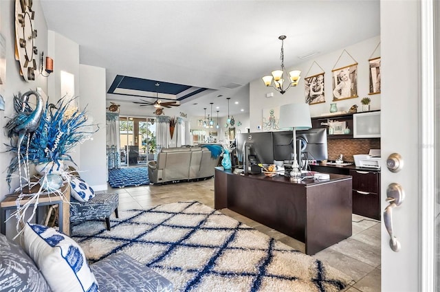 office area with a tray ceiling, light tile patterned flooring, and ceiling fan with notable chandelier