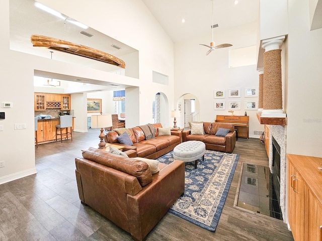 living room with a high ceiling, dark hardwood / wood-style floors, and ceiling fan