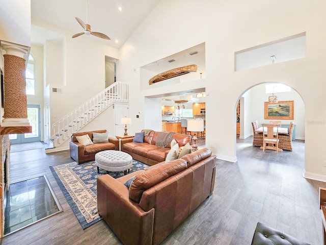 living room featuring ceiling fan, dark hardwood / wood-style flooring, and a high ceiling