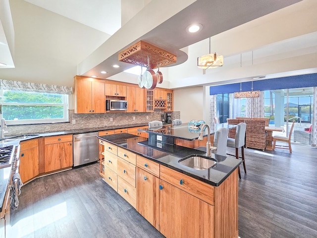 kitchen featuring sink, dark hardwood / wood-style floors, decorative light fixtures, a kitchen island, and stainless steel appliances