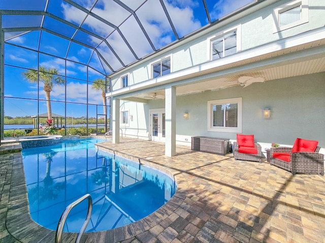 view of swimming pool with ceiling fan, a patio area, a lanai, and french doors