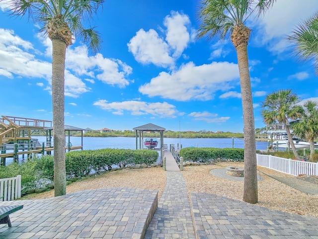 view of property's community with a fire pit, a boat dock, and a water view