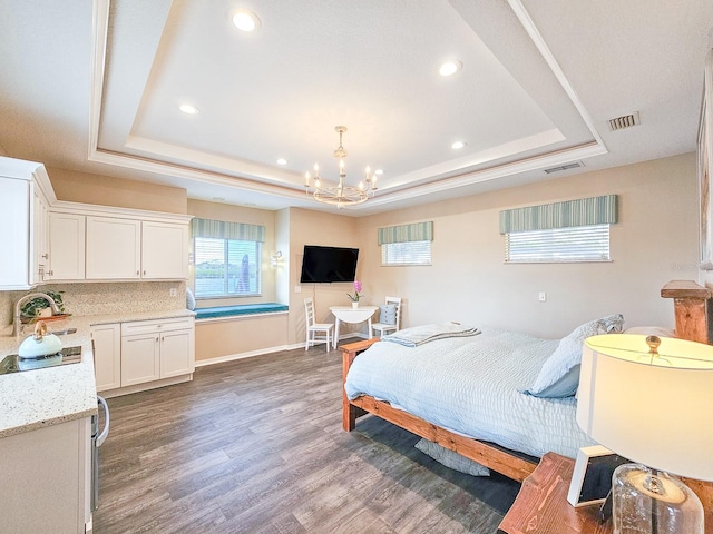 bedroom featuring a chandelier, dark hardwood / wood-style floors, a raised ceiling, and sink