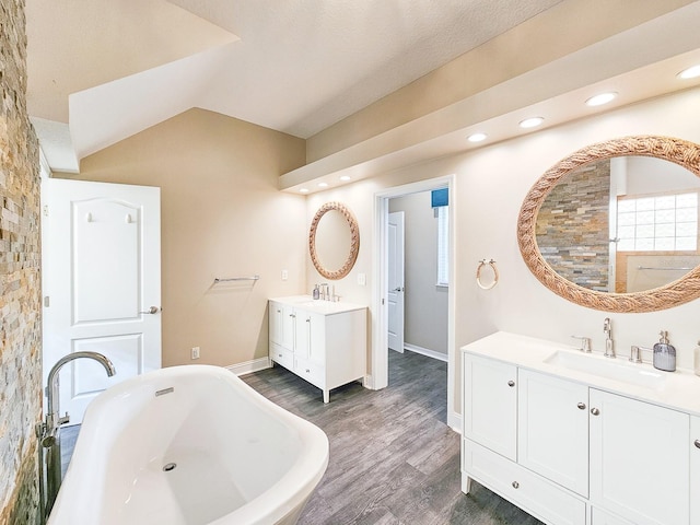 bathroom with vanity, hardwood / wood-style flooring, and a bathtub