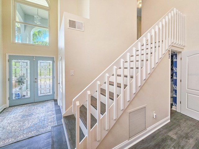 entrance foyer featuring dark hardwood / wood-style flooring, french doors, and a high ceiling