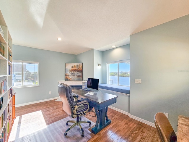 home office with hardwood / wood-style floors and a textured ceiling