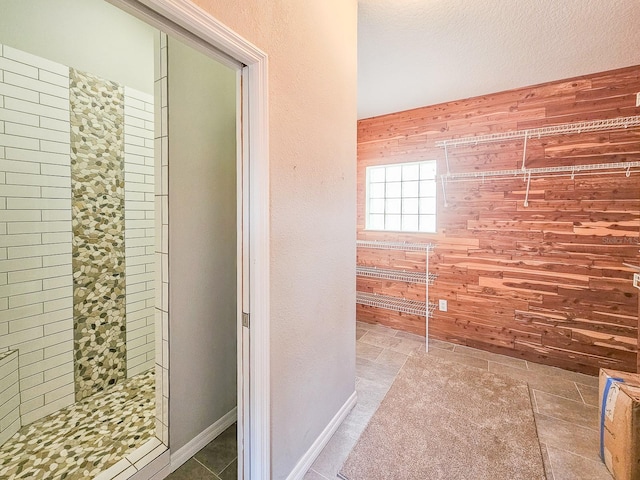 bathroom with wooden walls and tiled shower