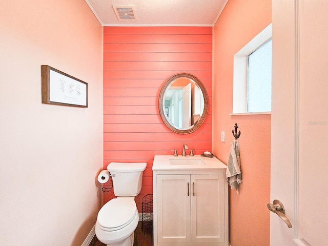 bathroom featuring crown molding, vanity, a textured ceiling, and toilet