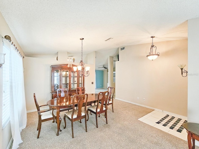 dining area featuring a textured ceiling, a healthy amount of sunlight, and carpet