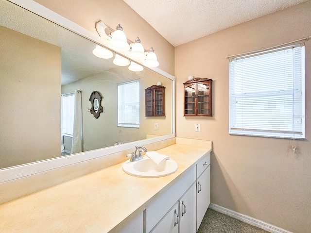 bathroom featuring a textured ceiling, vanity, and plenty of natural light