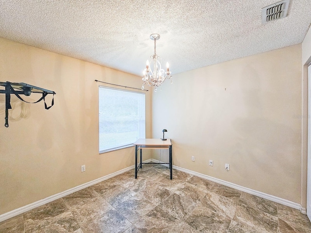 interior space with an inviting chandelier and a textured ceiling