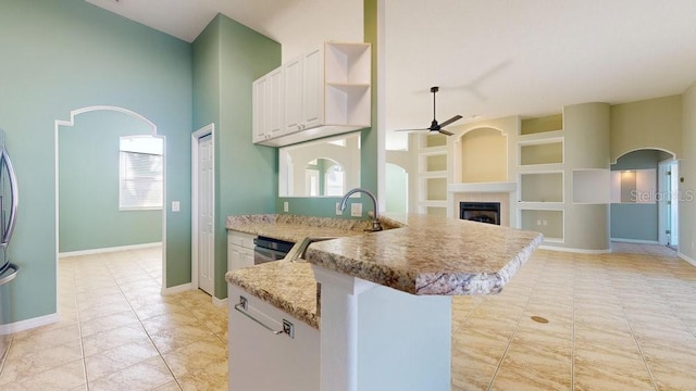 kitchen featuring stainless steel dishwasher, ceiling fan, built in features, and white cabinetry