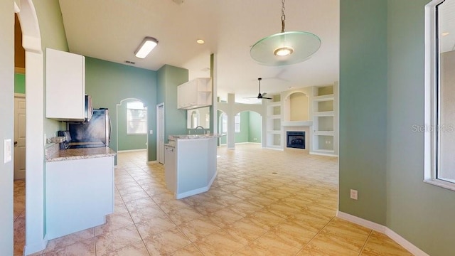 kitchen with pendant lighting, white cabinets, sink, ceiling fan, and built in shelves