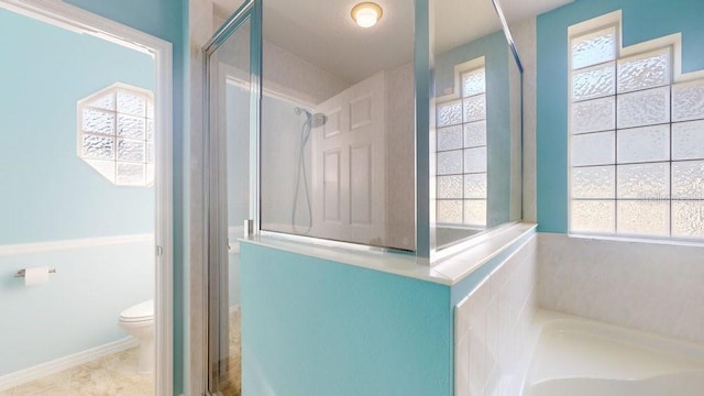 bathroom with separate shower and tub, toilet, and a wealth of natural light