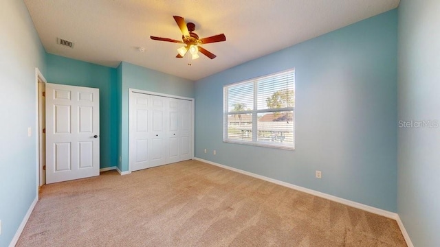 unfurnished bedroom featuring a closet, ceiling fan, and light colored carpet